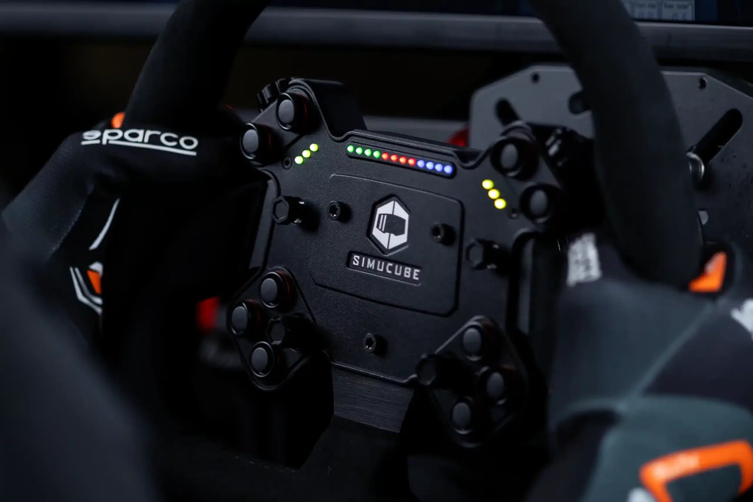 Close-up of a high-performance racing simulator steering wheel with LED indicators and Sparco branding.