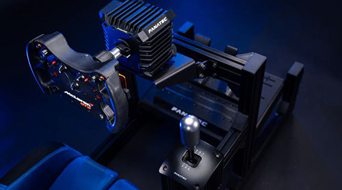 High-end racing simulator setup with steering wheel and gear shifter on black frame in a dimly lit room.