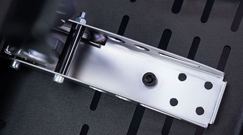 Close-up view of a metal bracket with multiple holes, used in mechanical or construction applications.