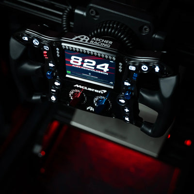 Simucube 2 Pro + Ascher Racing McLaren Artura Ultimate steering wheel in racing simulation setup with digital display close-up.