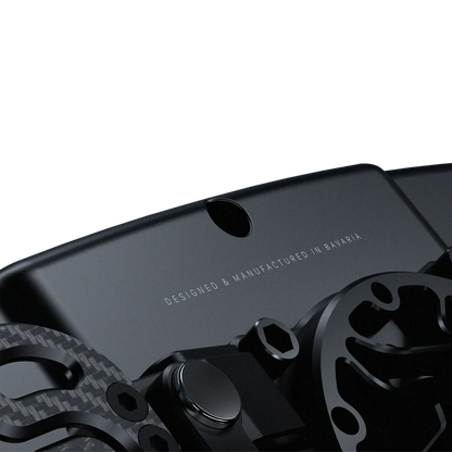 BavarianSimTec OmegaPRO v2 steering wheel with CNC-machined aluminium design, LCD screen, and dual-clutch paddles.