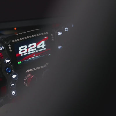 Simucube 2 Pro + Ascher Racing McLaren Artura Ultimate steering wheel on display, showcasing advanced racing simulation technology.